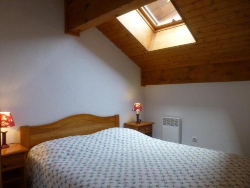 une chambre avec un lit et une lucarne dans l'établissement Appartement duplex avec balcon et animaux admis, proche pistes - Vallandry - FR-1-757-103, à Landry