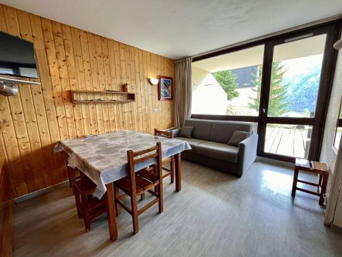 un salon avec une table et un canapé dans l'établissement Spacieux appart 2 pièces pour 9 personnes avec terrasse à Plan Peisey - FR-1-757-104, à Peisey-Nancroix