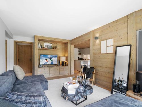 un soggiorno con un divano e uno specchio di Appartement skis aux pieds avec 6 couchages adultes et espace bien-être - FR-1-562-82 a Courchevel