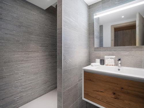 un bagno con lavandino e specchio di Appartement skis aux pieds avec 6 couchages adultes et espace bien-être - FR-1-562-82 a Courchevel