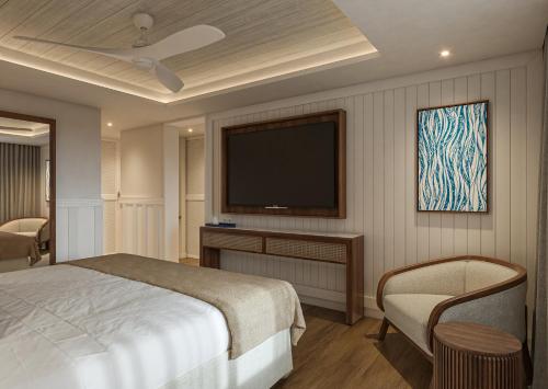 a bedroom with a bed and a flat screen tv at Secrets Saint Lucia Resort & Spa - All Inclusive in Gros Islet