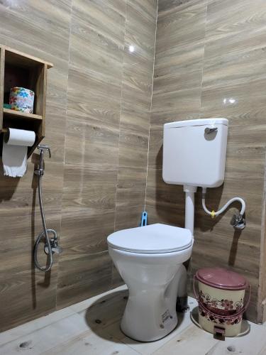 a bathroom with a white toilet in a room at Corbett Nature Retreat in Rāmnagar