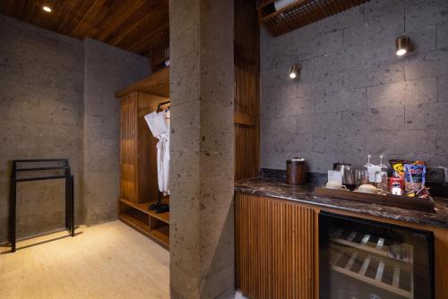 a kitchen with a counter and a pillar in a room at Sanctoo Suites & Villas in Gianyar