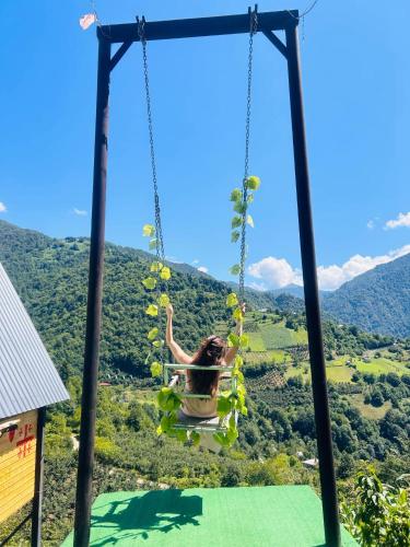 a woman is swinging on a swing at Eco cottage sunrise merisi in Merisi