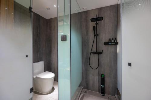 a bathroom with a glass shower with a toilet at True Go Hotel Beijing Jianguomen Pediatric Institute in Beijing