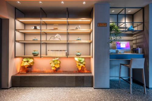 a room with a fireplace in the wall with plants at True Go Hotel Beijing Jianguomen Pediatric Institute in Beijing