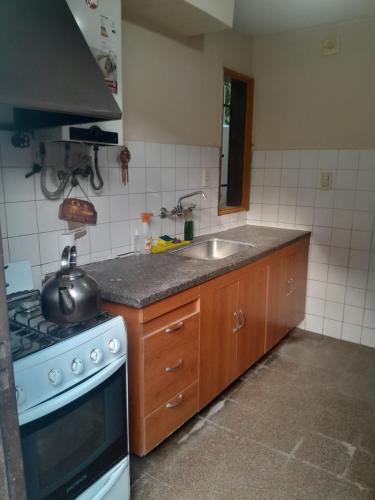 a kitchen with a sink and a stove top oven at Casa familiar de dos plantas in Guaymallen