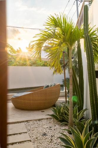 a wooden tub sitting on a patio next to a palm tree at Pagi Villas by Betterplace in Canggu
