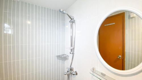 a bathroom with a mirror and a shower at Cozy Living and Homey Studio Room Cinere Resort Apartment By Travelio in Depok