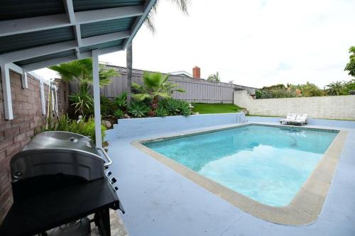 a swimming pool with a grill next to a house at Sunny San Diego, Entire home, Pool, Free Parking, BBQ, Pets allowed, family neighborhood! in San Diego