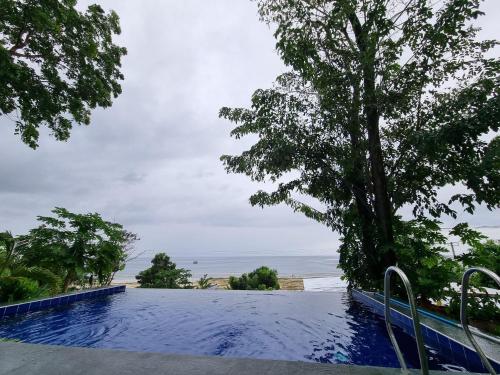 a swimming pool with a view of the ocean at Ocean View Villa in Bohol in Lila