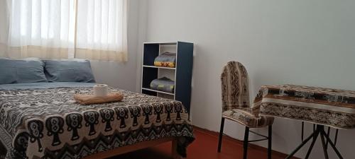 a bedroom with a bed and a chair with a candle on it at Hospedaje Vacacional - Colca in Chivay