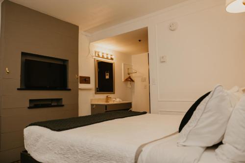 a hotel room with a bed and a flat screen tv at The Brooks Hotel Restaurant and Lounge in Wallace