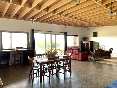 a living room with a dining room table and chairs at The Shedio On Saddleback in Kiama