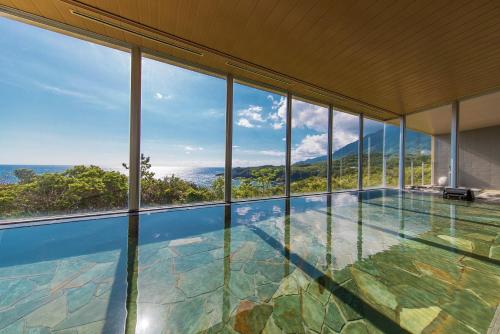 an indoor pool in a house with windows at samana hotel Yakushima in Yakushima