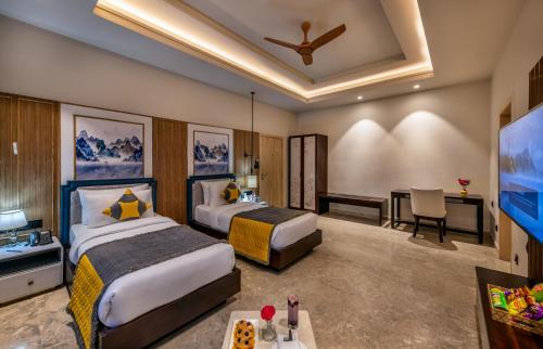 a hotel room with two beds and a flat screen tv at Ananta Spa & Resort Jaipur in Jaipur