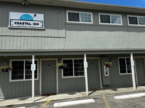 a building with doors and a sign that reads central inn at Coastal Inn and Suites in Long Beach