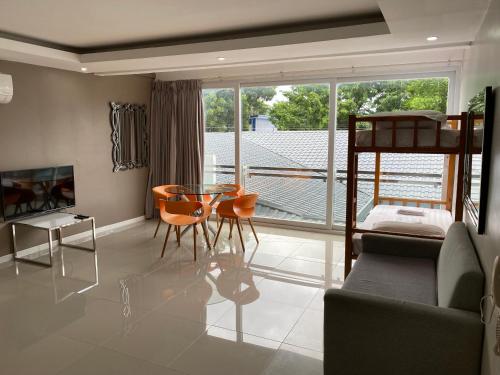 a living room with a bed and a table and chairs at Chequers Suites Subic Bay in Olongapo