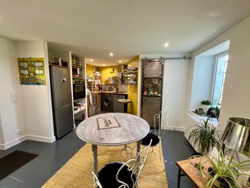 une cuisine avec une table et un réfrigérateur dans l'établissement Les hirondelles du marais, à Riom