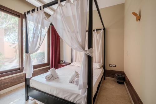 a bedroom with a canopy bed with white curtains at El Gouna 2 bedrooms apartment South Marina Ground Floor in Hurghada