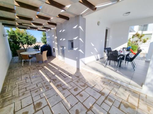 a patio with a table and chairs in a house at Beach Villa With Private Pool And BBQ 17 in Pervolia