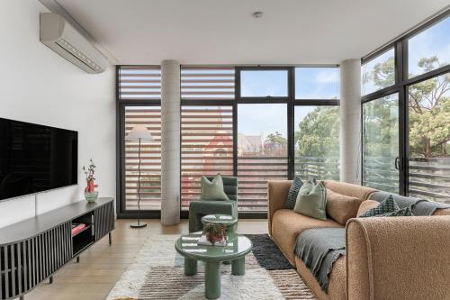 a living room with a couch and a tv at King Street Apartments by Urban Rest in Sydney