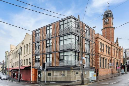 a brick building with a clock tower on a street at King Street Apartments by Urban Rest in Sydney