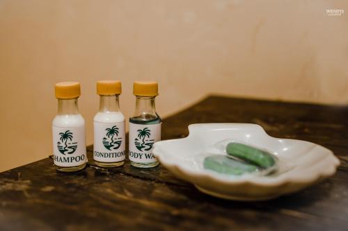 three bottles of soy sauce next to a white bowl at Rivendell Twisted Tree in Kurunegala
