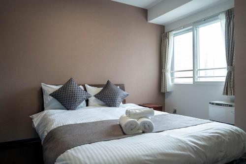 Un dormitorio con una cama con dos toallas encima. en Fancy2, en Sapporo
