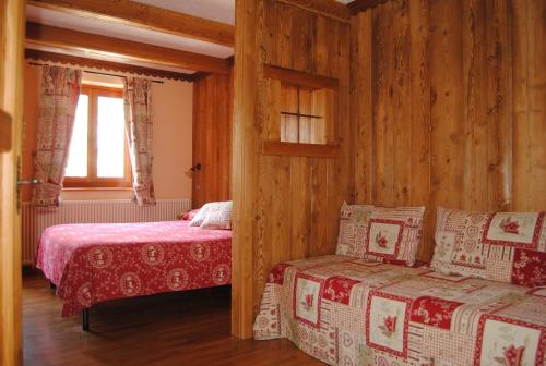 a bedroom with two beds and a couch and a window at Chalet Plan Gorret in Courmayeur