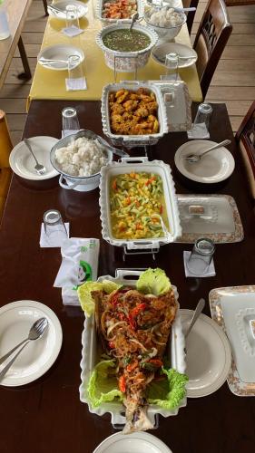 a table topped with food and plates of food at NASRUL HOUSE HOMESTAY FOR BACKPACKERS in Maros