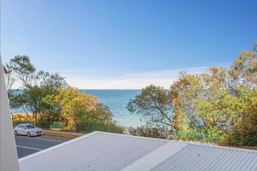 a car parked on a road next to the ocean at Redvue Holiday Apartments in Redcliffe
