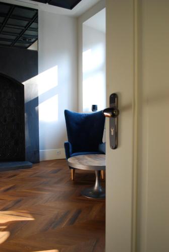 a room with a blue chair and a door at Hotel Nihil Novi in Radom
