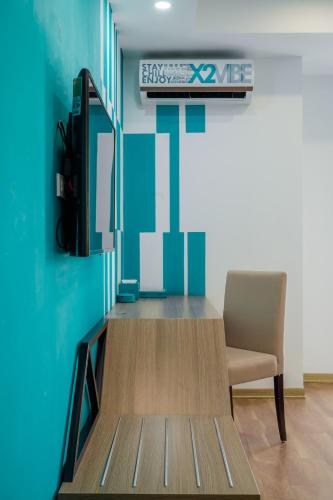 a waiting room with a chair and a television at Khách Sạn X2 Vibe Việt Trì in Làng Tiên Cát