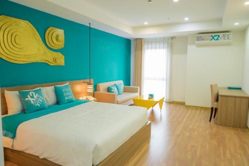 a bedroom with a large bed and a blue wall at Khách Sạn X2 Vibe Việt Trì in Làng Tiên Cát