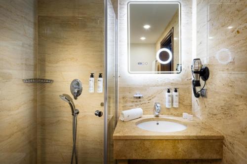 a bathroom with a sink and a shower at Rosslyn Thracia Hotel Sofia in Sofia