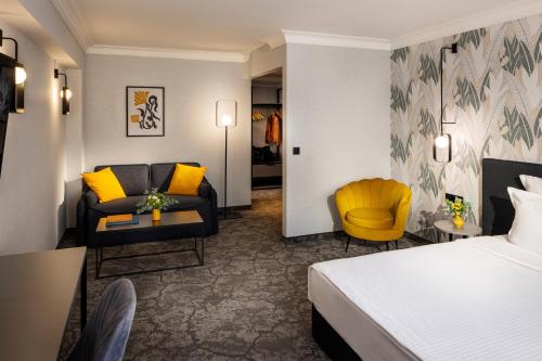 a hotel room with a bed and a living room at Rosslyn Thracia Hotel Sofia in Sofia