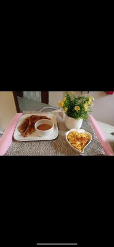 a table with a plate of food and a plate of pizza at Babes & Breakfast in Juan López