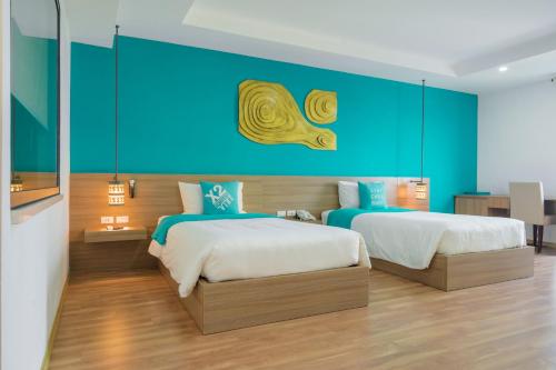 a bedroom with two beds and a blue wall at Khách Sạn X2 Vibe Việt Trì in Làng Tiên Cát