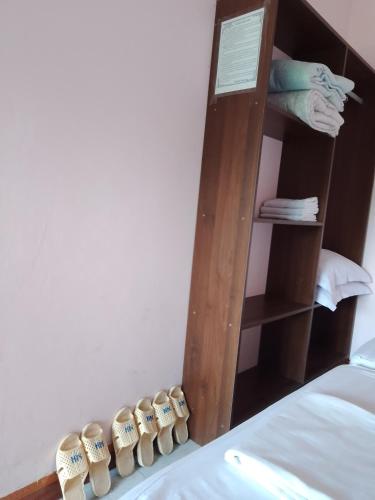 a wooden book shelf next to a bed with towels at Nhà nghỉ Hằng Nga in Dong Hoi