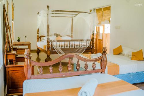 a bedroom with two beds and a wooden chair at Rivendell Twisted Tree in Kurunegala