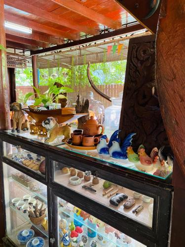 a glass display case filled with lots of ceramics at Banthai Guesthouse in Phetchaburi