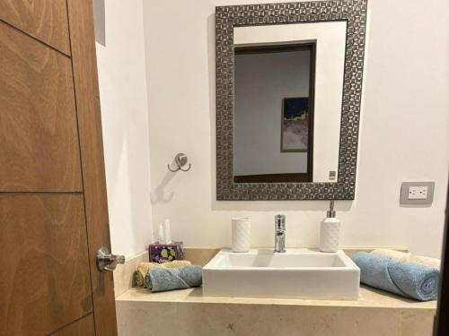 a bathroom with a sink and a mirror at Aztec Penthouse in Ensenada
