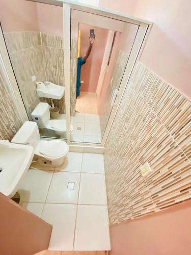 a person taking a picture of a bathroom with a toilet at Adouly Plaza Hotel in Saint-Raphaël
