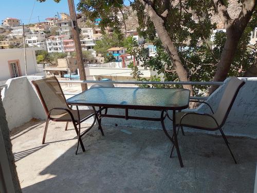 a table and two chairs sitting on a balcony at Carob Tree apartment, Tris Ekklisies in Paránimfoi