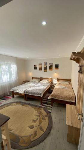 a room with three beds and a rug at Edelweiss in Lazeshchyna