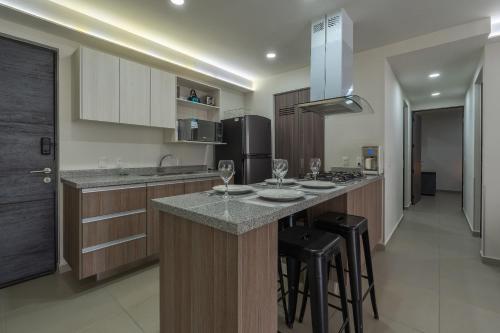 a kitchen with a island with bar stools and appliances at Modern Apartment with Terrace and Pool Access in Guadalajara