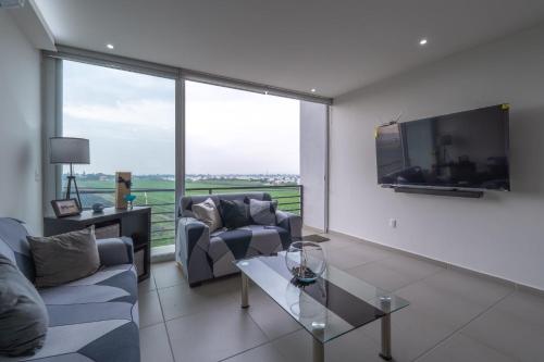 a living room with two couches and a large tv at Modern Apartment with Terrace and Pool Access in Guadalajara