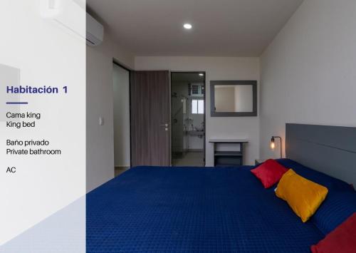 a bedroom with a blue bed with two colorful pillows at Modern Apartment with Terrace and Pool Access in Guadalajara
