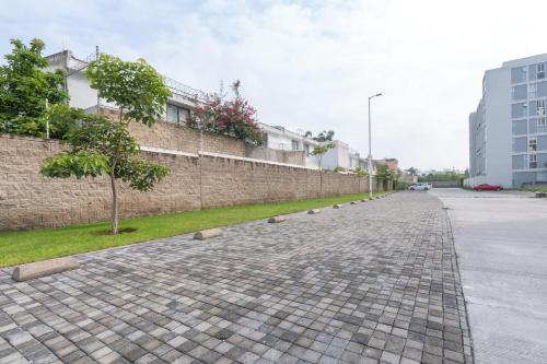 a cobblestone street next to a brick wall with a tree at Modern Apartment with Terrace and Pool Access in Guadalajara